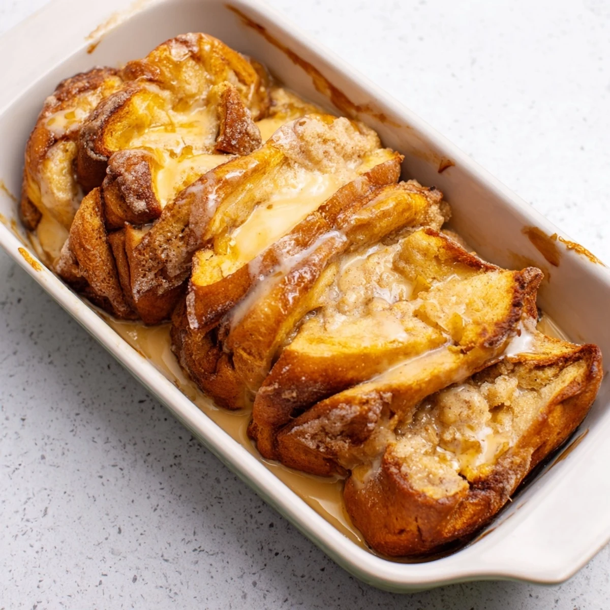 Golden, glistening Soft Spice Baked French Toast Casserole, ready to be served with warm maple syrup.