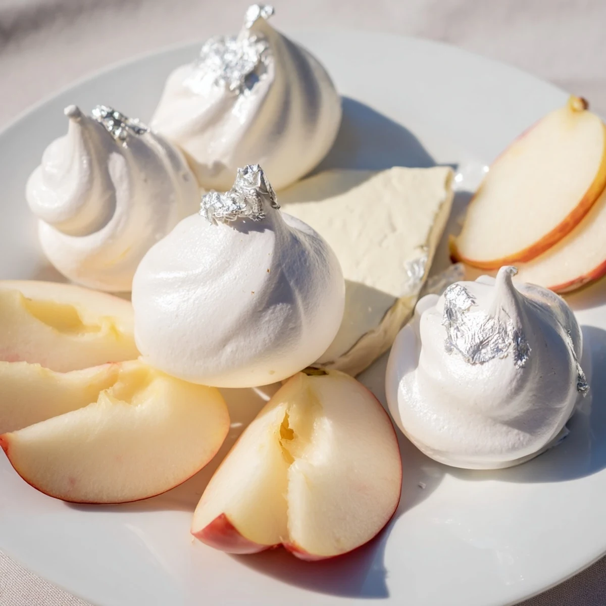 Elegant The Pearly Gates cheese board features creamy brie, crisp meringue, and juicy white peaches.