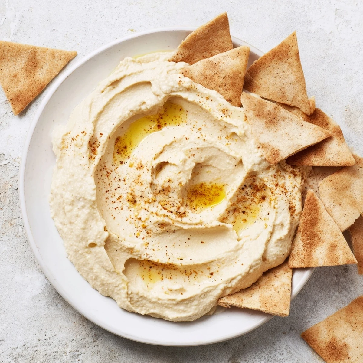 Creamy Sahara Dune hummus appetizers, sculpted to resemble desert dunes, served with crispy, spiced pita chips.