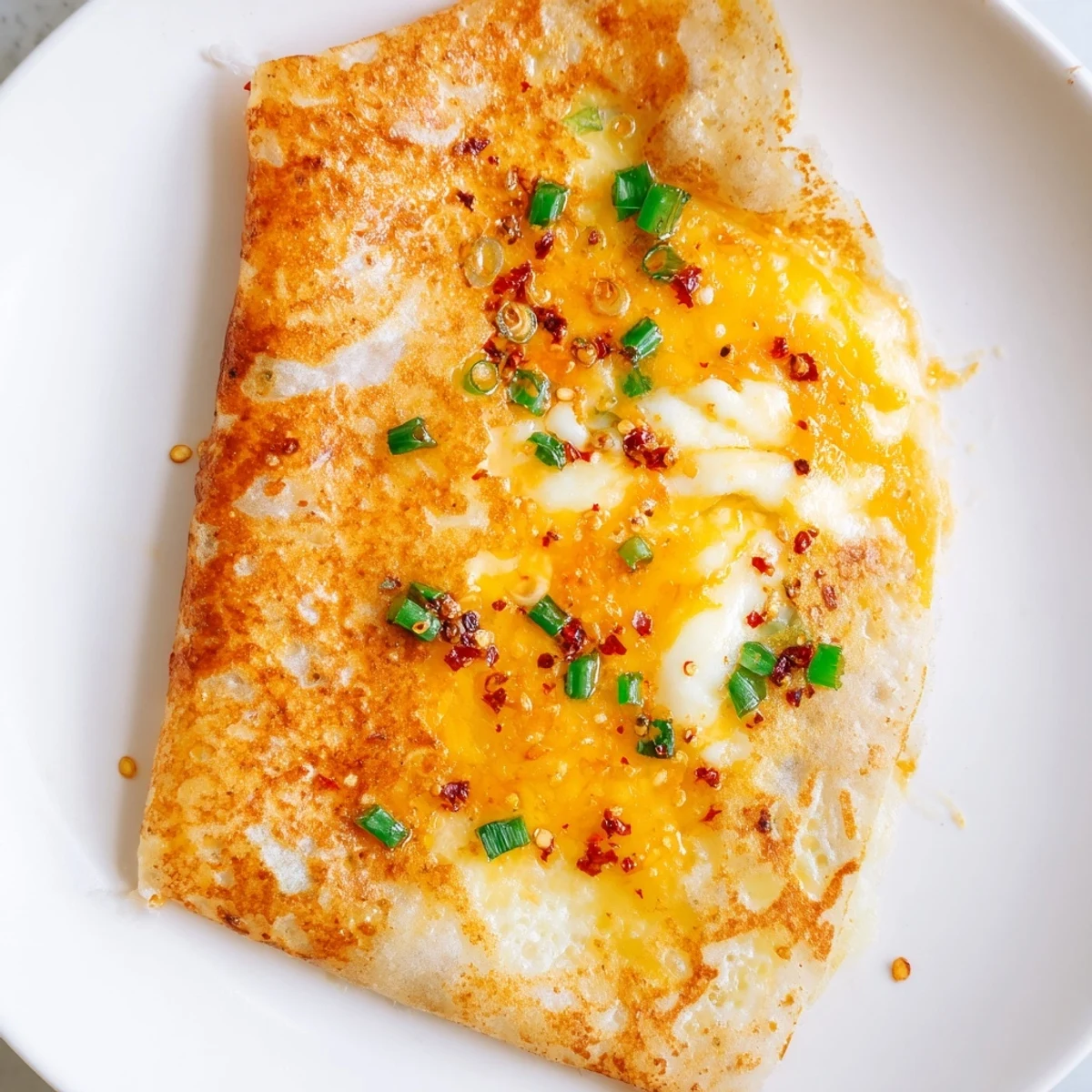 Golden-brown Rice Paper Egg Cheese Wrap, filled with melted cheese, ready to eat for breakfast.