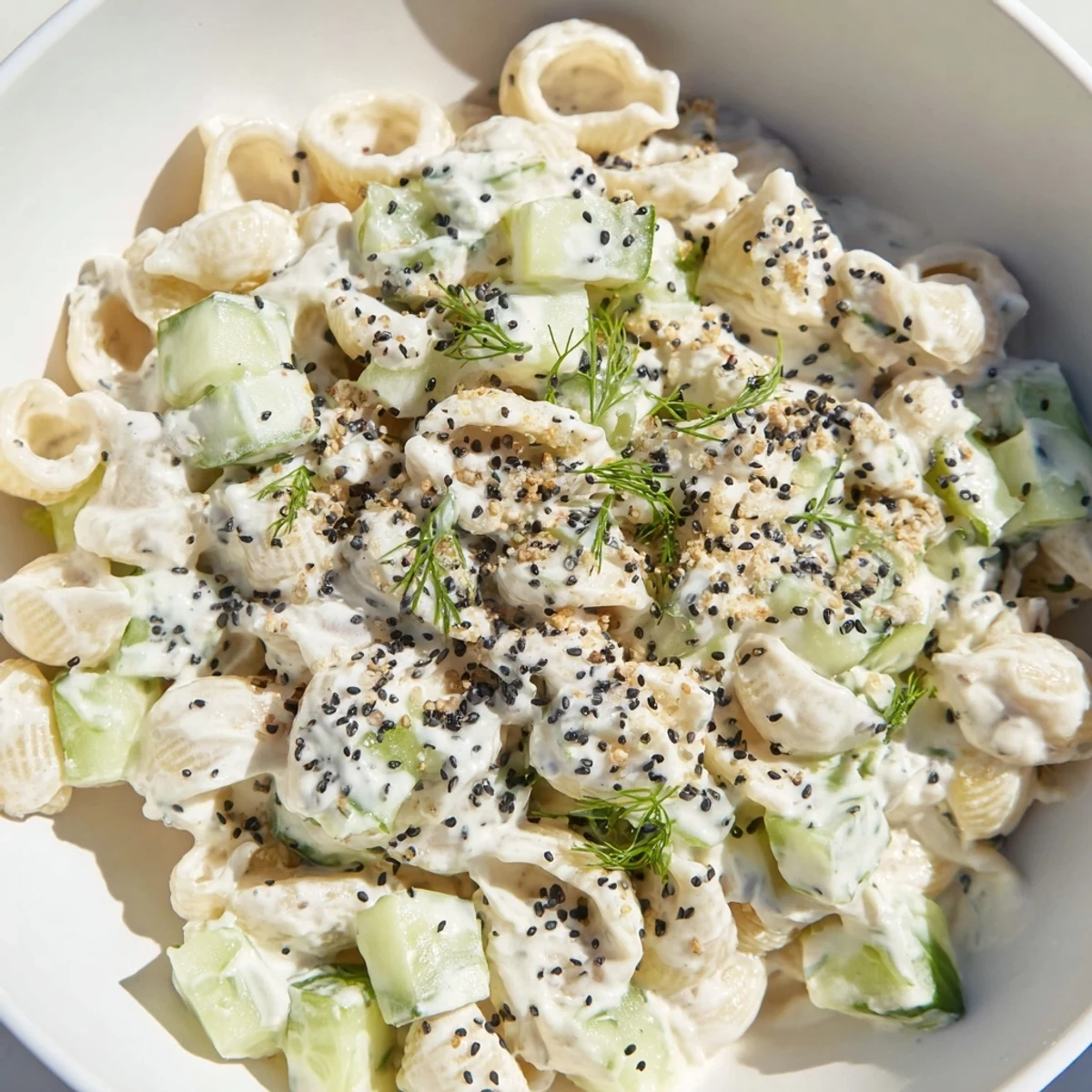 Vibrant Cucumber Crunch Pasta Salad in a white bowl, highlighting crunchy textures and creamy dressing, perfect for easy American side dishes.