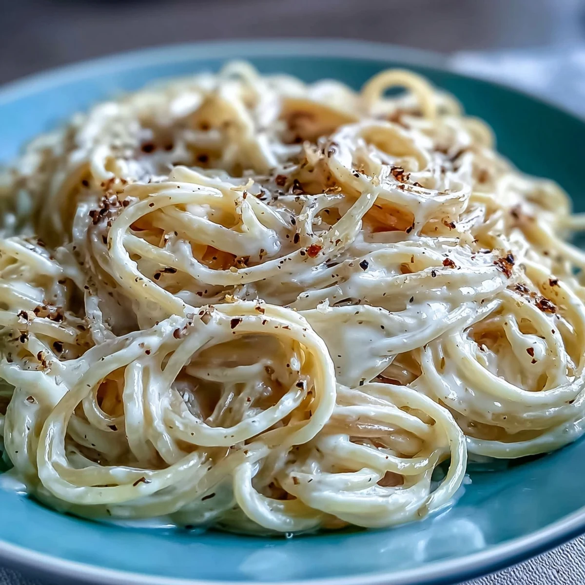 A steaming skillet of Cacio e Pepe features al dente spaghetti tossed with grated cheese, perfect for a quick Italian weeknight dinner.