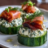 Refreshing cucumber slices topped with herbed cream cheese and savory smoked salmon, perfect for brunch or parties.  