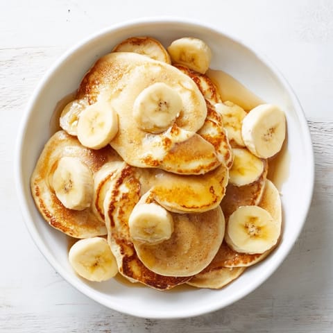 Golden Weekend Banana Pancakes served warm, drizzled with maple syrup for a delightful brunch.