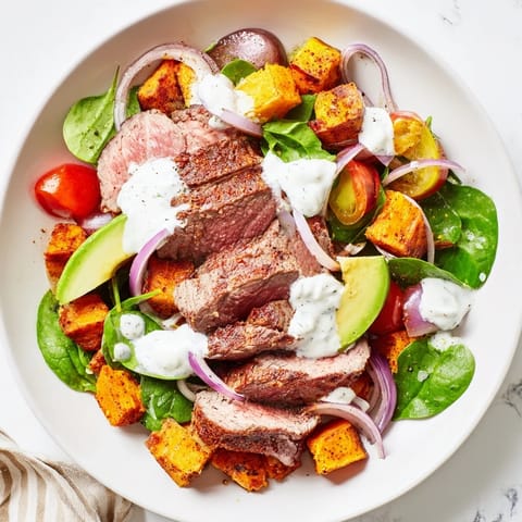 This healthy beef avocado sweet potato bowl features colorful veggies, juicy beef, and tangy dressing.