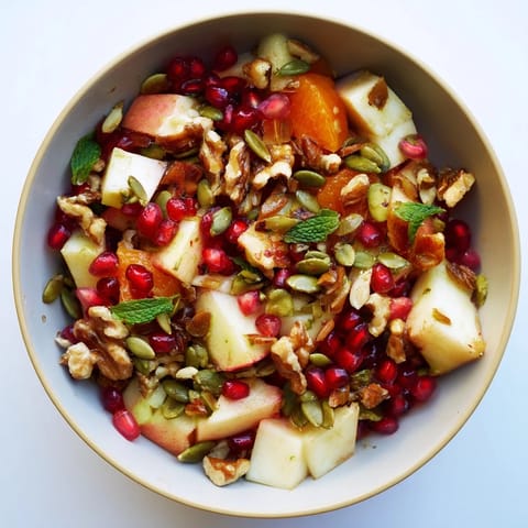 A vibrant Pomegranate and Walnut Salad with juicy orange segments, crunchy nuts, and fresh mint garnish, ready for a refreshing winter meal.