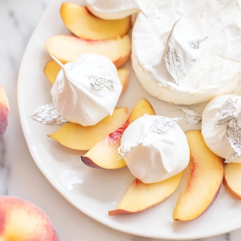 Heavenly The Pearly Gates cheese board with silver leaf garnish and sweet meringue kisses for serving.