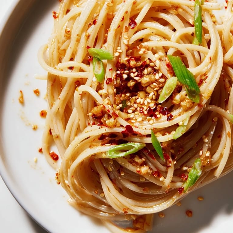 Vibrant red Garlic Chili Oil Noodles: a close-up shows perfectly coated, glossy noodles ready to eat.