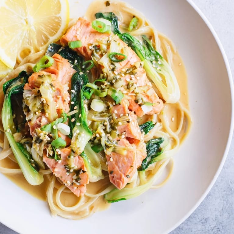Tender salmon fillets coated in rich miso butter sauce, served over pasta and fresh baby bok choy.